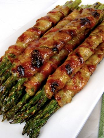 overhead view of Grilled Bacon Wrapped Asparagus on white plate